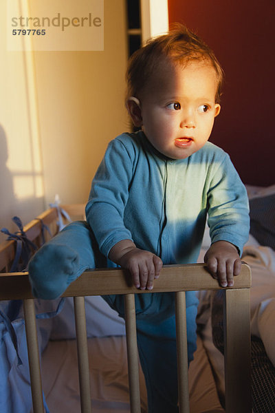 Baby Mädchen klettert aus der Krippe