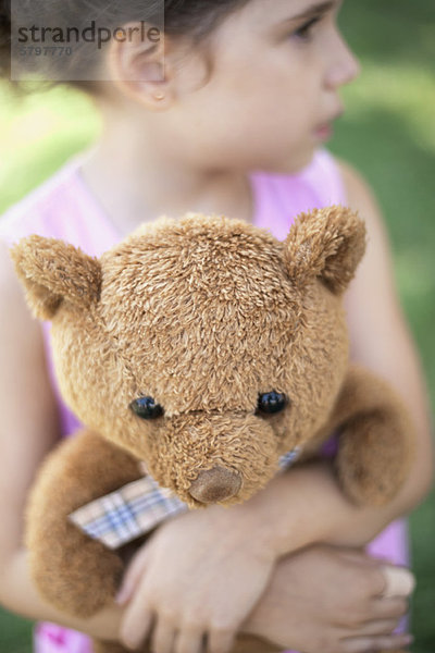 Mädchen umarmt Teddybär