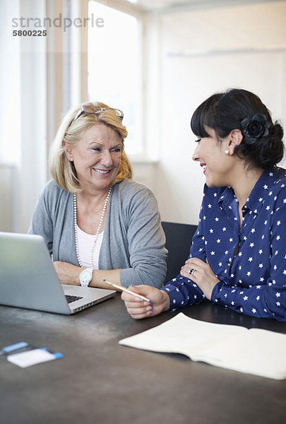 Zwei Unternehmerinnen lächeln im Büro
