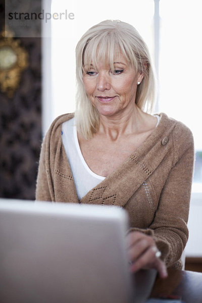 Senior Frau mit Laptop zu Hause