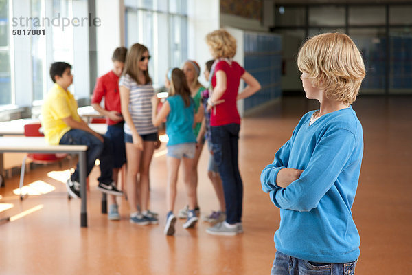 Junge dreht sich zu einer Gruppe von Schulkindern um