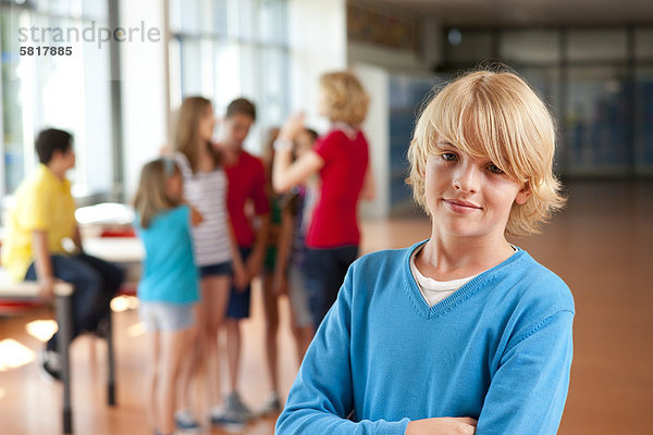 Lächelnder Junge vor einer Gruppe von Schulkindern