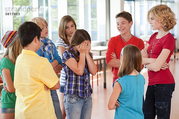 Mädchen wird von einer Gruppe von Schulkindern geärgert