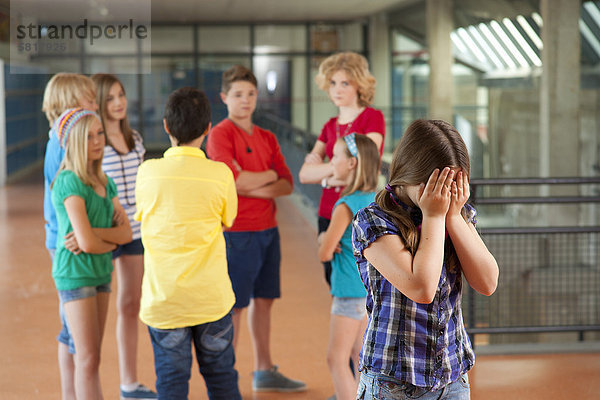 Mädchen wird von einer Gruppe von Schulkindern geärgert