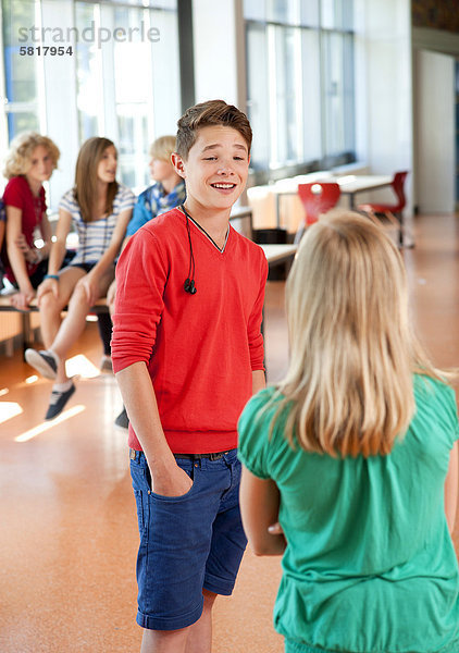 Teenager lächelt eine Teenagerin in der Schule an