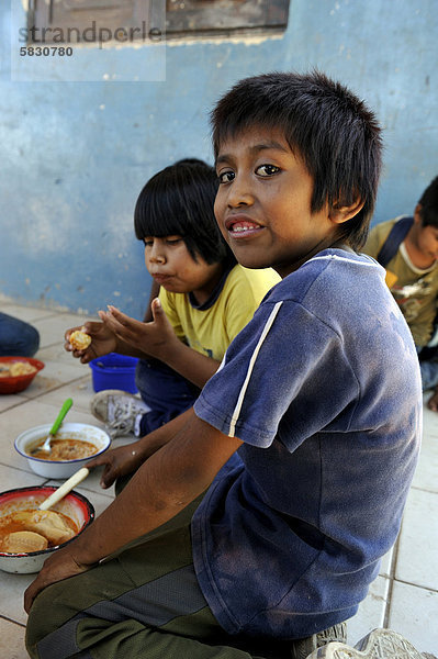 Jungen bekommen in der Dorfschule Mittagessen  Gemeinde des indigenen Volkes der Wichi  Comunidad Tres Pocos  Provinz Formosa  Argentinien  Südamerika
