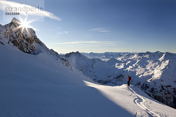 hinter  Europa  Berg  Skifahrer  verstecken  Berggipfel  Gipfel  Spitze  Spitzen  Skisport  Skiabfahrt  Abfahrt  Österreich  Sonne  Tirol