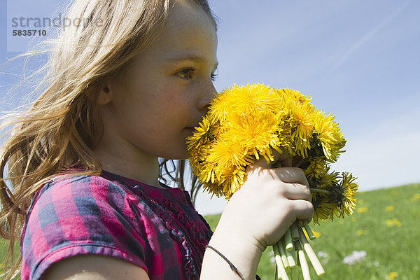 Mädchen riechende Wildblumen im Feld