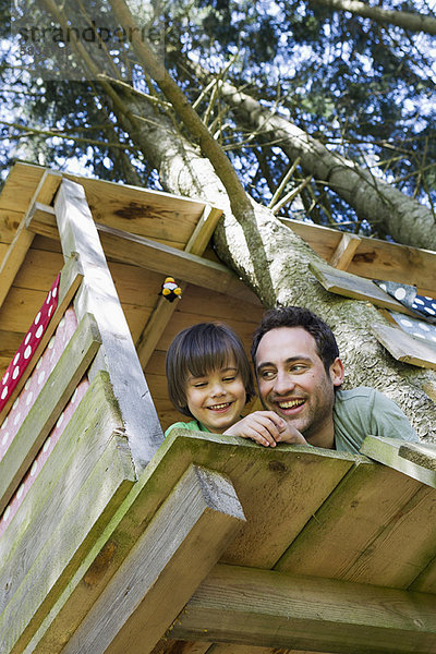 Vater und Sohn spielen im Baumhaus