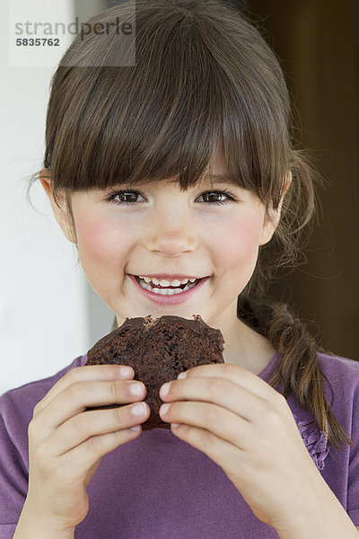 Nahaufnahme des lächelnden Mädchens beim Essen von Brownie