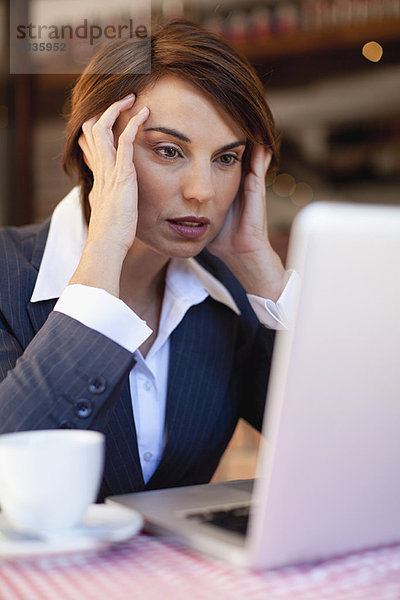 Gestresste Geschäftsfrau bei der Arbeit im Café