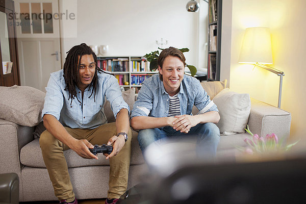 Männer spielen Videospiele im Wohnzimmer