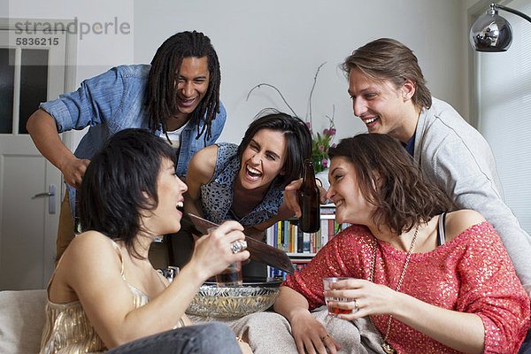 Freunde lachen zusammen im Wohnzimmer