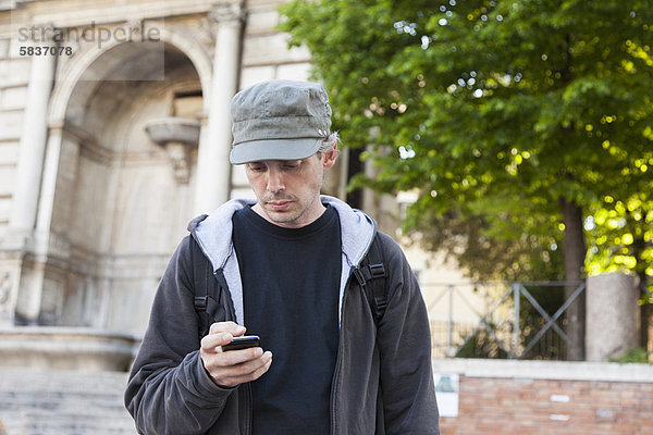 Mann mit Handy auf der Stadtstraße