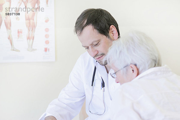 Arzt im Gespräch mit dem Patienten im Büro