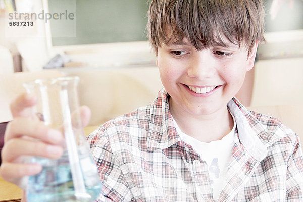 Schüler untersuchen Flüssigkeit im Becherglas