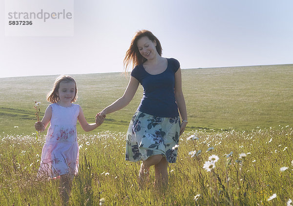 Mutter und Tochter beim Spaziergang auf dem Feld