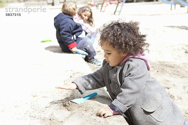 Mädchen spielen mit Sand auf dem Spielplatz