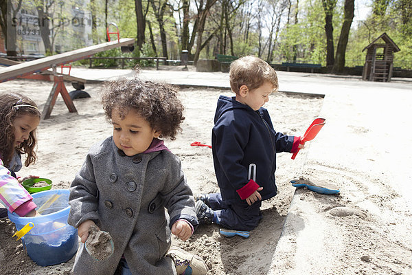 Kinder spielen mit Sand auf dem Spielplatz