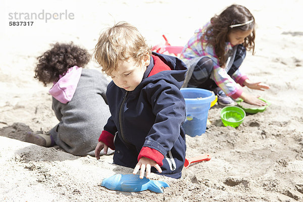 Kinder spielen mit Sand auf dem Spielplatz