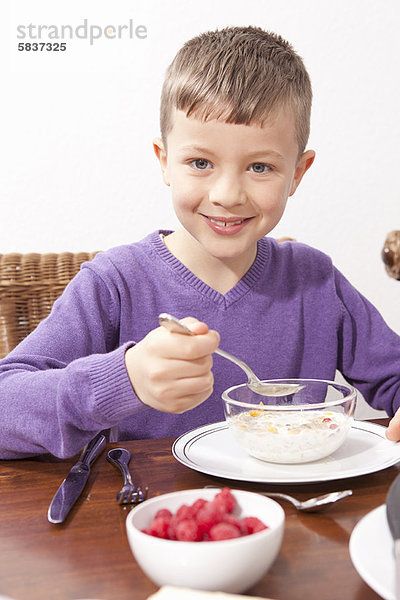 Junge - Person  essen  essend  isst  Tisch  Frühstück