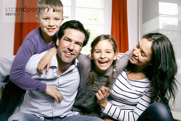 Familie lächelt gemeinsam auf dem Bett