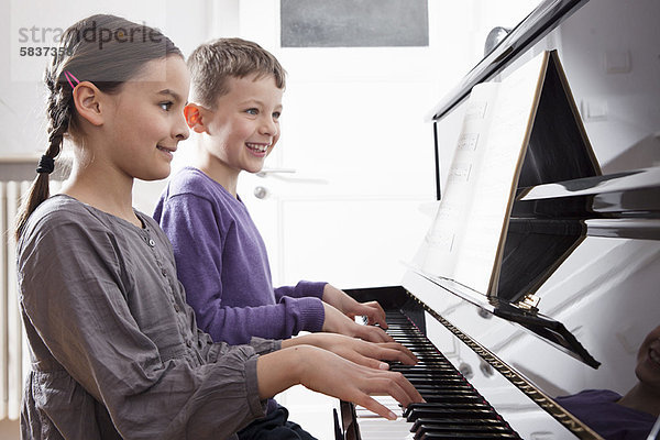 Bruder und Schwester beim Klavierspielen