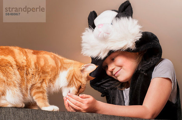 Mädchen in Katzenkostüm Fütterung Haustier Katze