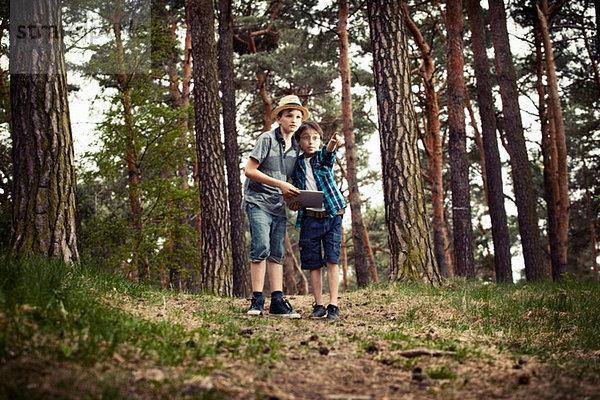 Jungen mit digitalem Tablett im Wald