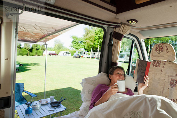 Reife Frau beim Lesen im Wohnmobil