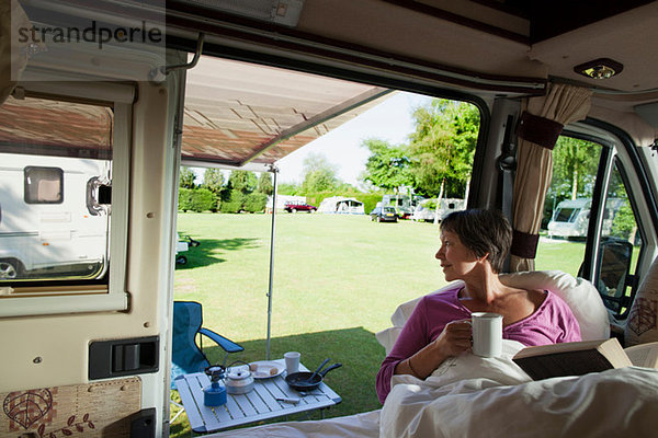 Reife Frau beim Lesen im Wohnmobil