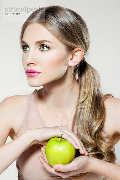 Junge Frau mit Apfel in der Hand