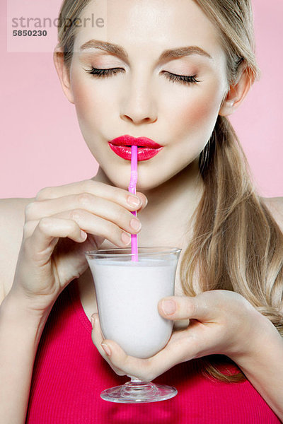 Junge Frau trinkt Milchshake