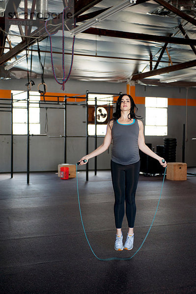 Schwangere junge Frau  die mit Seil springt
