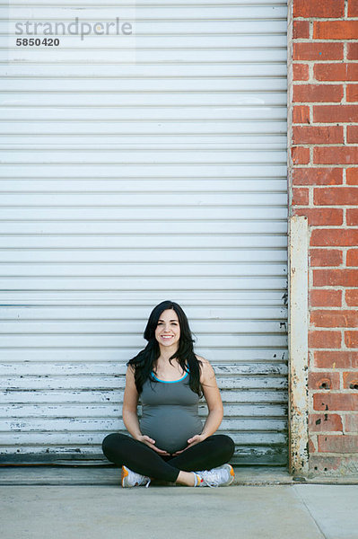 Schwangere junge Frau im Kreuzbein sitzend  Portrait