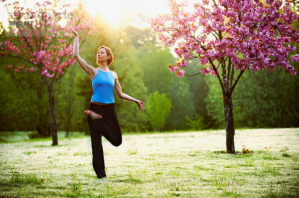 Frau in Yoga-Pose im Park