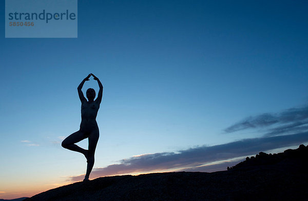 Junge Frau in Baumhaltung in der Wüste  Silhouette