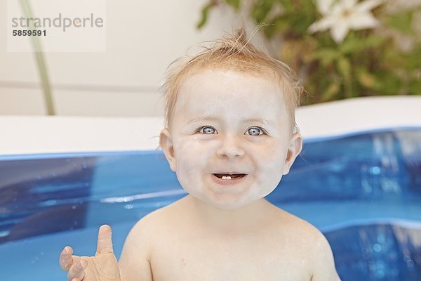 Weibliches Baby sitzt im Planschbecken