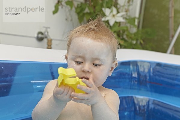 Weibliches Baby sitzt im Planschbecken