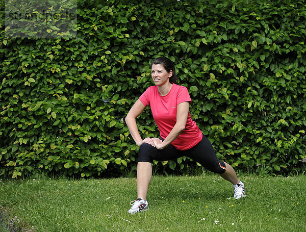 Junge Frau beim Aufwärmen  Dehnen vor Joggen  Stuttgart  Baden-Württemberg  Deutschland  Europa  ÖffentlicherGrund