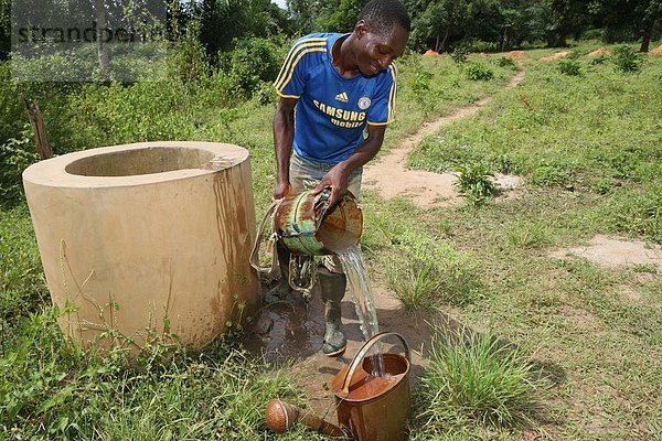 Mann Wasserholen vom Brunnen  Tori  Benin  Westafrika  Afrika