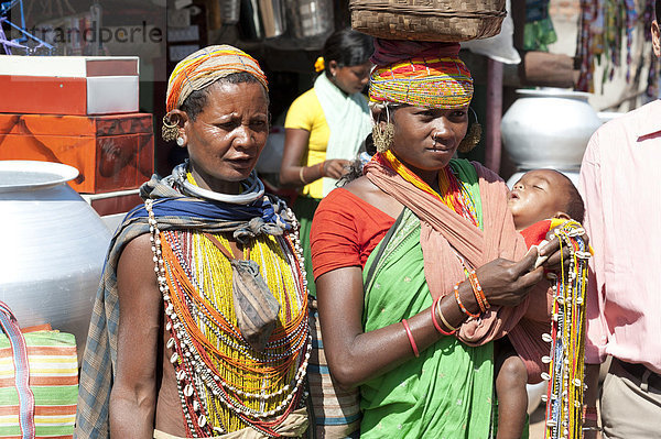 Zwei Bonda Tribeswoman und Baby in traditionellen Perlen Kostüm und Halsketten tragen zeitgenössischen Kostüm  wulstige Kappen und Ohrringe  Rayagader  Orissa  Indien  Asien
