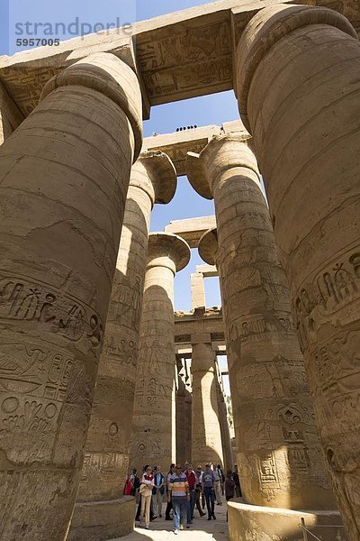 Touristen in den Schatten gestellt von den hoch aufragenden Säulen der großen Hypostyle Halle von der Karnak-Tempel des Amun  Theben  UNESCO World Heritage Site  Ägypten  Nordafrika  Afrika