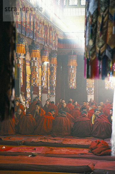 Mönche innerhalb der großen Gebetshalle  Drepung buddhistischen Kloster  Lhasa  Tibet  China  Asien