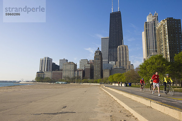 Jogger und Radfahrer am Lake Michigan mit der Skyline von Near North hinter  Oak Street Beach  Chicago  Illinois  Vereinigte Staaten von Amerika  Nordamerika