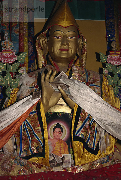 Statue mit Schals und Angeboten des Geldes in Ganden Kloster  Tibet  China  Asien