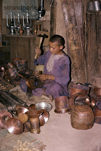 Ein Junge Hämmern aus einem Kupfer Topf in Tashkurgan  Afghanistan  Asien