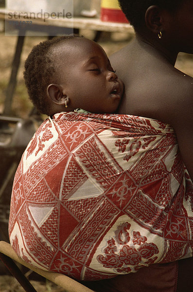 Kind schläft auf des Mädchens zurück  in der Nähe von Abidjan  Elfenbeinküste  Westafrika  Afrika