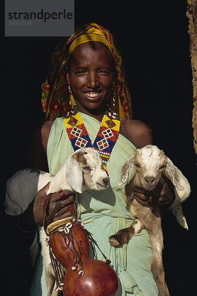 Frau holding Zweibettzimmer Kid Ziegen und Kürbis  und das Tragen von Perlen  Harar  Äthiopien  Afrika