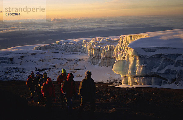 Wanderer und Gletscher bei Sonnenaufgang am Gipfel des Kibo  5895m  Kilimanjaro Nationalpark  Tansania  Ostafrika  Afrika